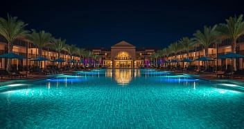 Beleuchtetes Erwachsenenhotel mit luxuriöser Poollandschaft bei Nacht