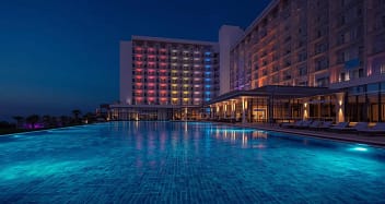 Modernes Erwachsenenhotel mit Infinity Pool und beleuchteter Fassade bei Nacht – Adults Only Resort