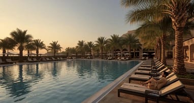 Luxus Resort mit Pool und Palmen bei Sonnenuntergang